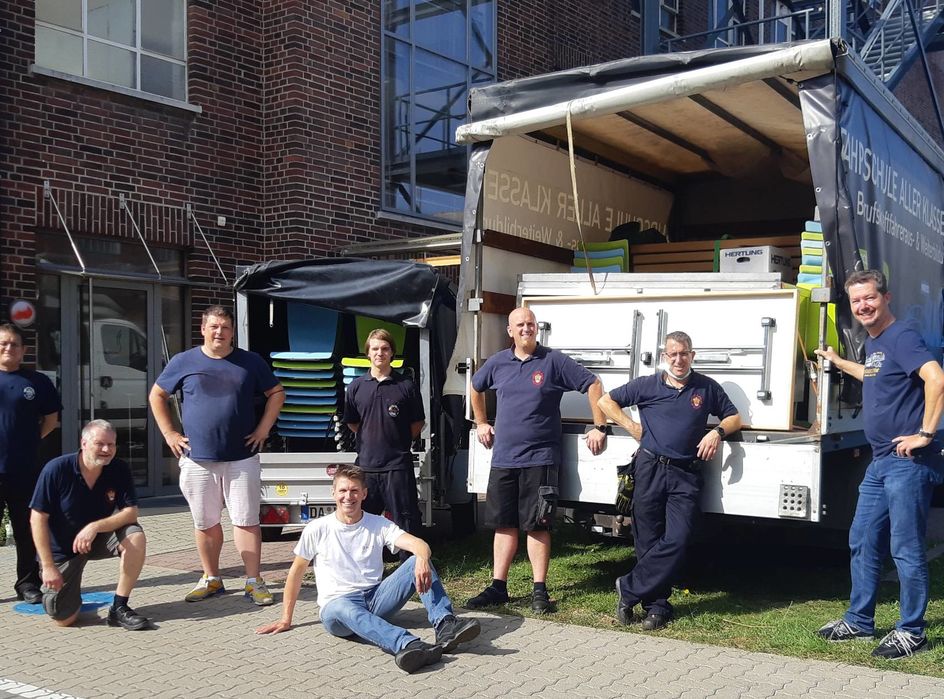 Männer der Tat: Jonathan Kaidas, Oliver Buchholzer, Marcus Buß, Sascha Görg, Silas Vollrath, Christian Luetke, Jürgen Seibel und Thorsten Umland nach dem Packen des Transportfahrzeugs vor dem alten Kantinengebäude von Evonik am Standort Darmstadt. Foto: Evonik