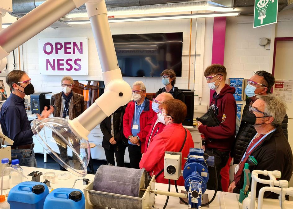 Patrik Stenner, Evonik Verfahrenstechnik, erläutert den interessierten Besuchern das elektrochemische Verfahren, mit dem Mikroplastik aus Abwasser abgetrennt werden kann. Foto: Evonik Industries